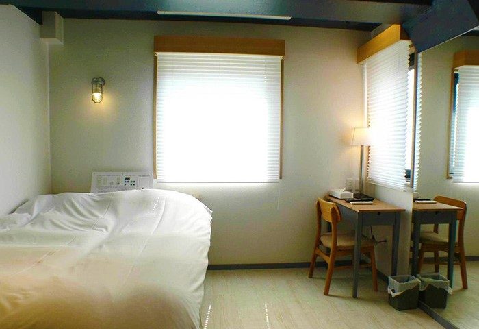 Shinjuku City Hotel N.U.T.S Tokyo room. Gay-friendly hotel room with bed, desk, chair, and window. Shinjuku hotel for gay travelers.