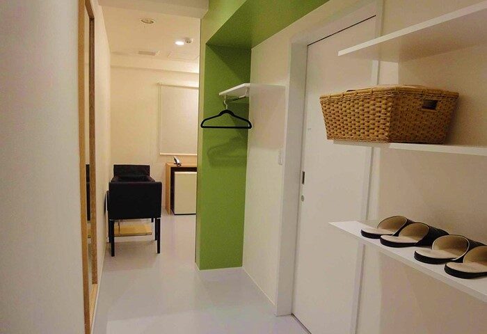 Shinjuku City Hotel N.U.T.S Tokyo room interior. A gay-friendly hotel with modern design, shelves, slippers, and a comfortable, inviting space.