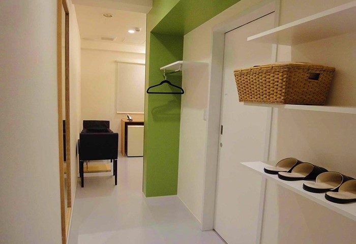 Shinjuku City Hotel N.U.T.S Tokyo room interior. A gay-friendly hotel with modern design, shelves, slippers, and a comfortable, inviting space.