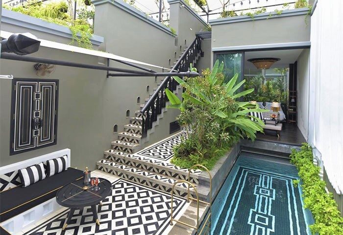 Shinta Mani Angkor gay-friendly hotel pool villa. Stylish outdoor space with pool, stairs, and seating. Luxury travel for gay men.