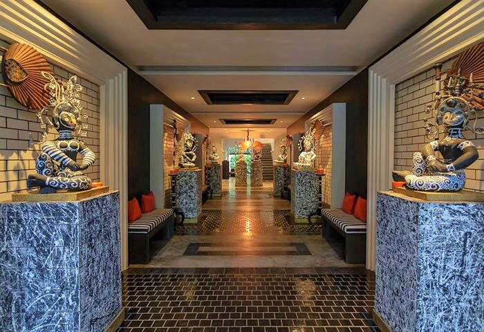 Shinta Mani Angkor's stylish interior. This gay-friendly hotel features unique sculptures, brick walls, and elegant benches. Ideal for gay travel.