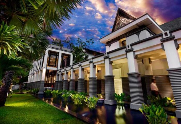 Shinta Mani Angkor pool villas exterior view. Gay-friendly hotel with luxury architecture, lush greenery, and tranquil water features.