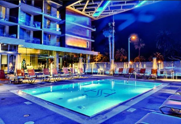 Shore Hotel's pool at night. This gay-friendly hotel offers a relaxing atmosphere. Loungers surround the pool, perfect for a gay getaway.