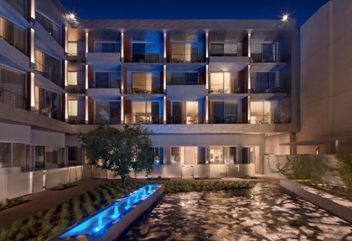 Shore Hotel: Exterior view of this gay-friendly hotel at night, featuring a courtyard with a water feature and illuminated balconies.