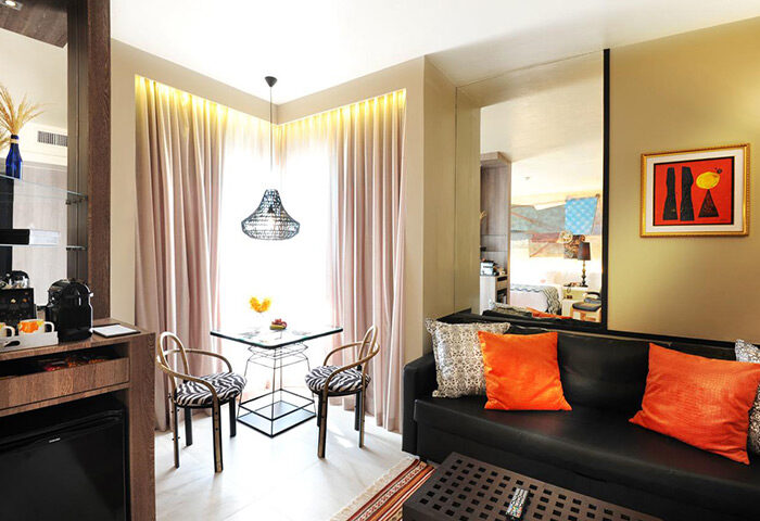 Siam @ Siam Design Hotel Bangkok room. Gay-friendly hotel interior with table, chairs, & sofa. Modern design in a Bangkok hotel.