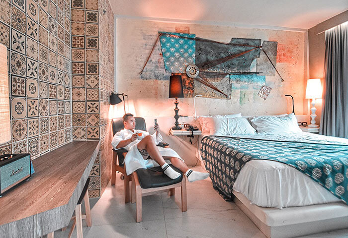 Gay man relaxing in Siam @ Siam Design Hotel Bangkok room. Modern decor, stylish design. Gay-friendly hotel for LGBT travelers.