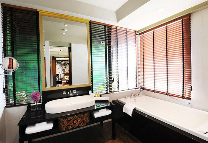 Siam @ Siam Design Hotel Bangkok bathroom. Gay-friendly hotel features a tub, sink, and window blinds. Luxury design in Bangkok.