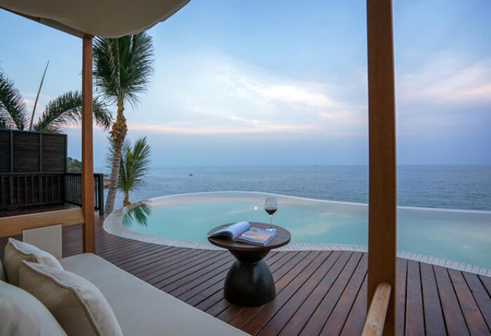 Silavadee Pool Spa Resort's gay-friendly hotel view. Infinity pool, wine, and ocean vista from a luxurious suite. Perfect gay travel destination.