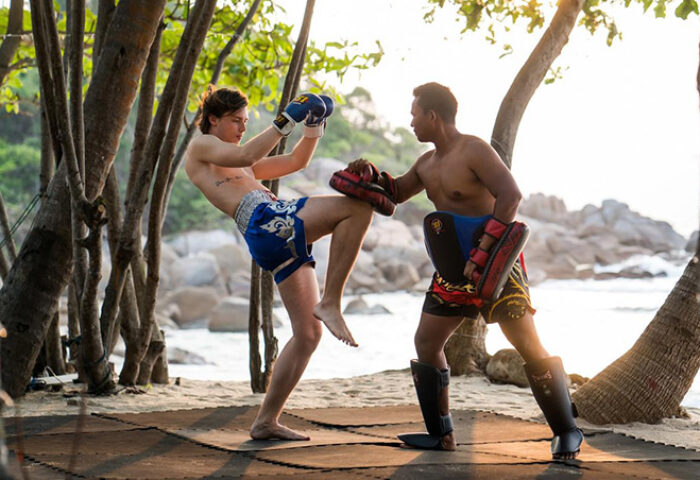 Gay-friendly Silavadee Pool Spa Resort: Muay Thai training on the beach. A shirtless guest practices kickboxing with an instructor.