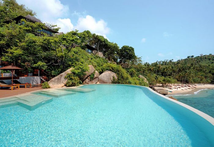 Silavadee Pool Spa Resort's infinity pool overlooking beach. Gay-friendly hotel with spa, perfect for gay men's travel. Tropical paradise.