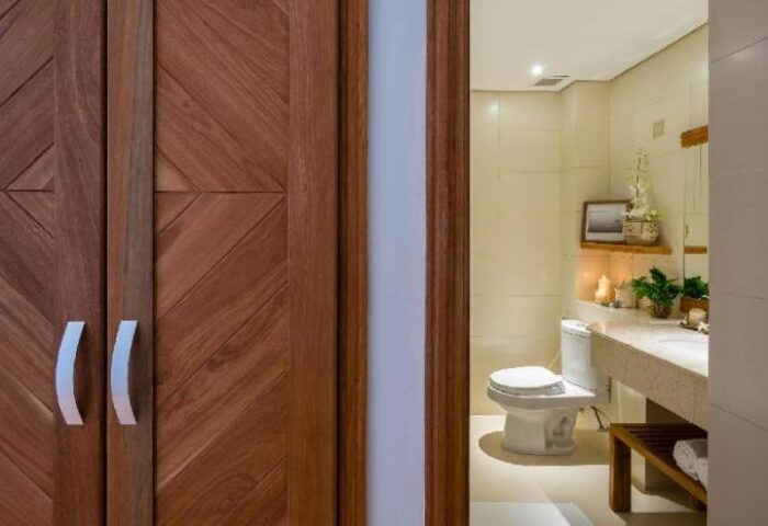 Bathroom at Silverland Yen Hotel, a gay-friendly hotel. Features a toilet, sink, and wooden accents. Ideal for gay men seeking stylish accommodations.