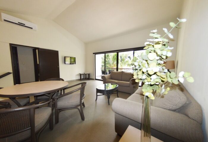 Sina Suites gay-friendly hotel living room. Interior view of seating area, table, and balcony. Modern design for gay travelers.