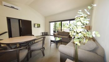 Sina Suites gay-friendly hotel living room. Interior view of seating area, table, and balcony. Modern design for gay travelers.