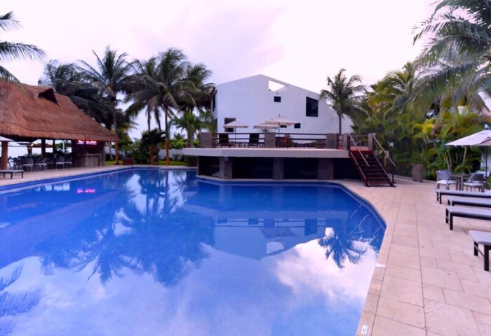 Sina Suites gay-friendly hotel pool view. Relax at this tropical resort with a bar, lounge chairs, and a refreshing pool. Perfect for gay men travel.