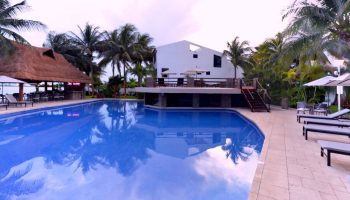 Sina Suites gay-friendly hotel pool view. Relax at this tropical resort with a bar, lounge chairs, and a refreshing pool. Perfect for gay men travel.