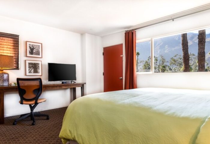 Skylark Hotel room interior. Gay-friendly hotel with a bed, desk, and mountain view from the window. Palm Springs hotel for gay travelers.