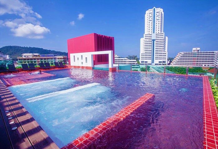 Rooftop pool at Sleep with Me Hotel, a gay-friendly design hotel in Patong, Thailand. Modern architecture and clear blue sky.