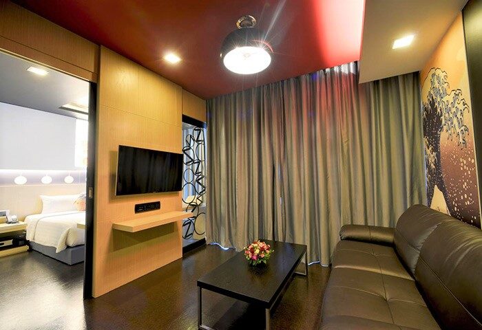 Sleep with Me Hotel Design Hotel at Patong, gay-friendly. Room view with bed, TV, couch, and table. Modern design in Patong, Thailand.