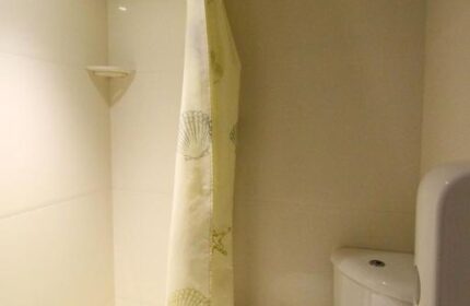 Bathroom at Smart Hyde Park Inn Hostel, a gay-friendly hotel. Features a toilet, shower with seashell curtain, and clean, modern design.