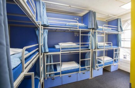 Smart Hyde Park Inn Hostel's dorm. Blue bunk beds with curtains for privacy. Gay-friendly hotel for budget travelers.