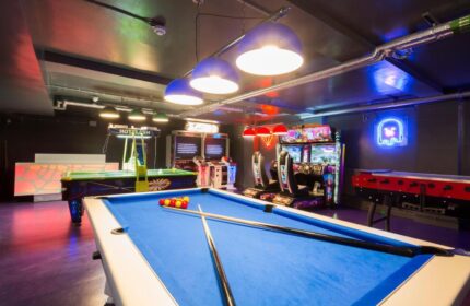So Hostel's game room with pool table, air hockey, foosball, and arcade games. A gay-friendly hotel offering entertainment for travelers.
