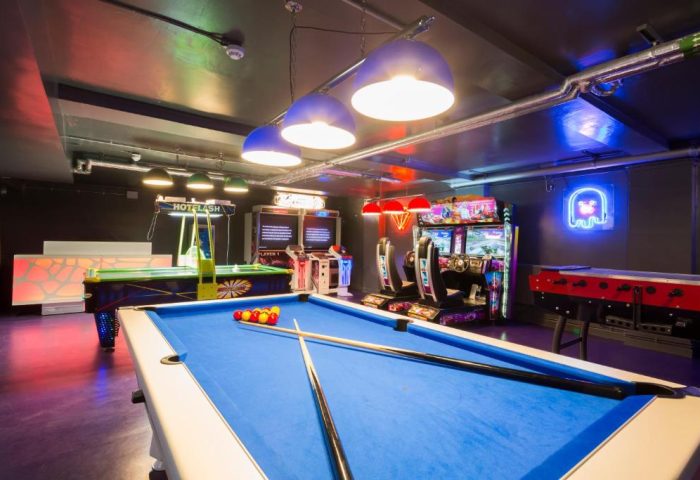 So Hostel's game room with pool table, air hockey, foosball, and arcade games. A gay-friendly hotel offering entertainment for travelers.