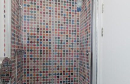 So Hostel gay-friendly hotel shower. Colorful polka dot tiles adorn the shower stall. Modern design for gay travelers. Hostel bathroom.