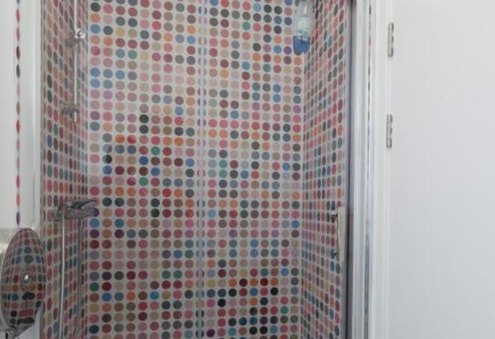 So Hostel gay-friendly hotel shower. Colorful polka dot tiles adorn the shower stall. Modern design for gay travelers. Hostel bathroom.