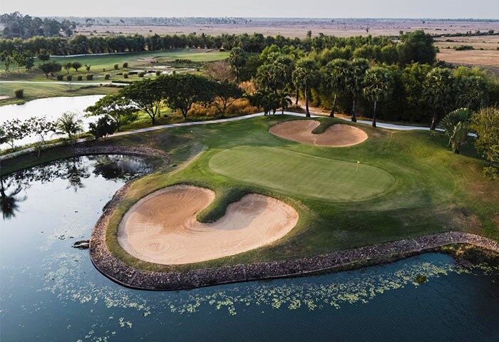 Sofitel Angkor Phokeethra Golf & Spa Resort's golf course. Gay-friendly hotel with lush green, sand traps, and a water hazard. Perfect for gay travel.