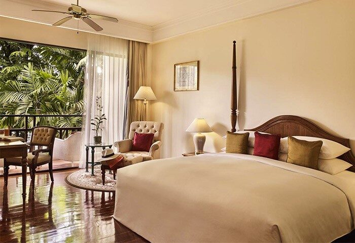 Sofitel Angkor Phokeethra Golf & Spa Resort room. Gay-friendly hotel with balcony, bed, chair, and desk. Luxury travel in Siem Reap.