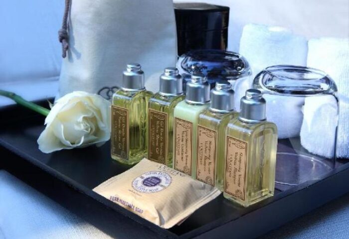 Sofitel Angkor Phokeethra Golf & Spa Resort bathroom amenities. L'Occitane products, soap, towels, and a rose on a tray. Gay-friendly hotel.