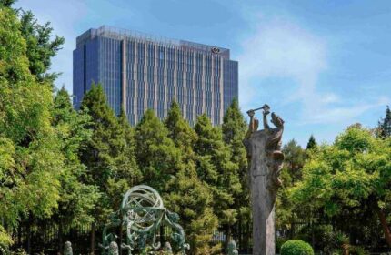Gay-Friendly Sofitel Beijing Central hotel view. Sculpture garden with modern building. Popular choice for gay men travelers in Beijing.