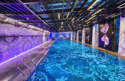 Indoor pool at the gay-friendly Sofitel Beijing Central hotel. The pool has a unique floral pattern and ambient lighting. Luxury travel.