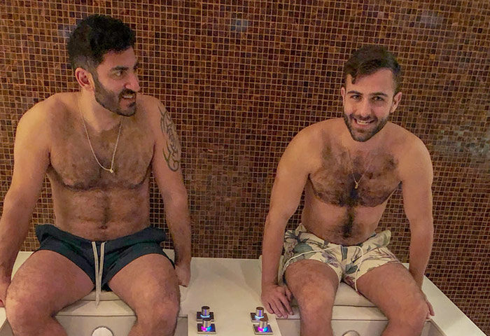 Two gay men relax at a spa in a gay-friendly hotel near Kurfurstendamm, Berlin. Enjoying a pet-friendly getaway.