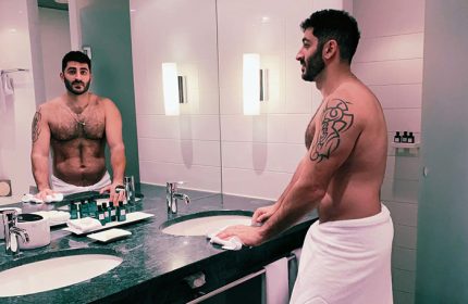 Gay-friendly hotel: Man with tattoo in towel in bathroom at Sofitel Berlin Kurfurstendamm Hotel. Pet-friendly hotel in Berlin.