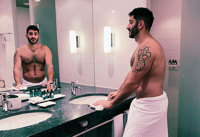Gay-friendly hotel: Man with tattoo in towel in bathroom at Sofitel Berlin Kurfurstendamm Hotel. Pet-friendly hotel in Berlin.