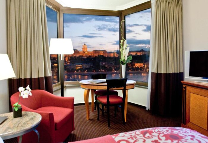 Sofitel Budapest Hotel room with a view. Pet-friendly, gay-friendly hotel room overlooks the Danube River and cityscape at dusk.