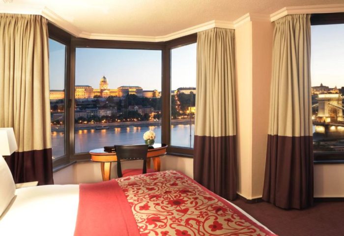 Sofitel Budapest Hotel room with Danube view. Gay-friendly, pet-friendly hotel. Room with river view. Budapest cityscape at dusk.