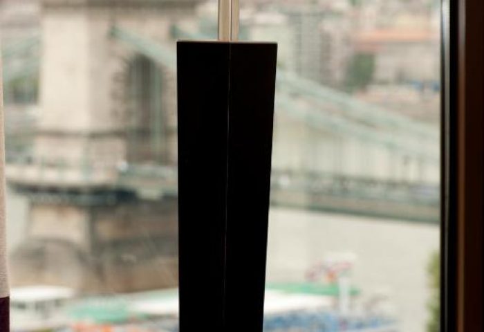 Sofitel Budapest Hotel room view. Lamp with a bridge and boat on the Danube River in the background. Gay-friendly, pet-friendly hotel.
