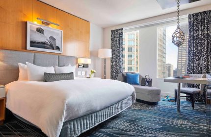 Sofitel Chicago Magnificent Mile gay-friendly hotel room. Bedroom with city view, desk, and chaise lounge. Upscale gay travel lodging.