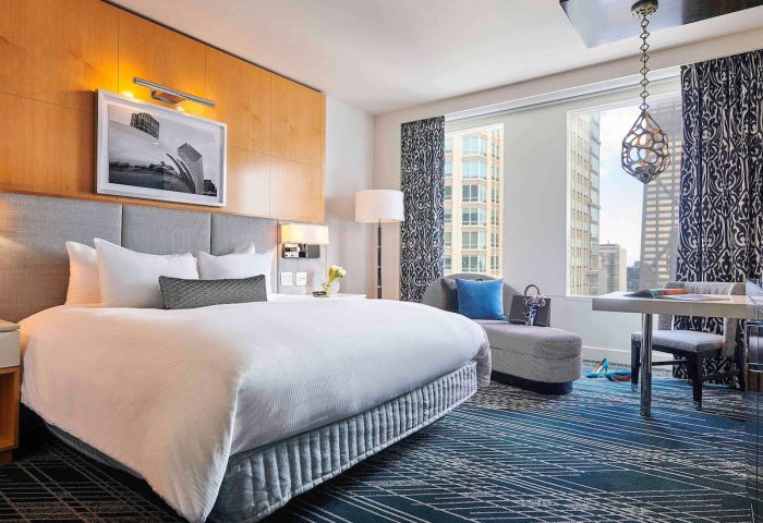 Sofitel Chicago Magnificent Mile gay-friendly hotel room. Bedroom with city view, desk, and chaise lounge. Upscale gay travel lodging.