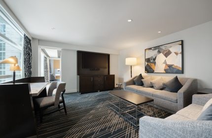 Sofitel Chicago Magnificent Mile gay-friendly hotel suite. Living area with sofa, desk, and TV. Upscale lodging for gay travelers.