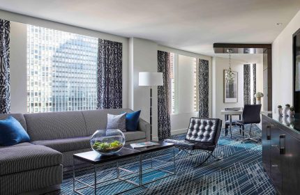 Gay-friendly Sofitel Chicago Magnificent Mile hotel room. Living area with sofa, chair, and city views. Upscale lodging.