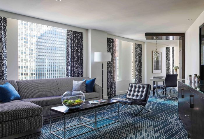 Gay-friendly Sofitel Chicago Magnificent Mile hotel room. Living area with sofa, chair, and city views. Upscale lodging.