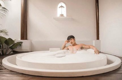 Gay-friendly Sofitel Krabi Phokeethra Golf & Spa Resort: Man relaxing in a bubble bath. Luxury travel experience in Thailand.