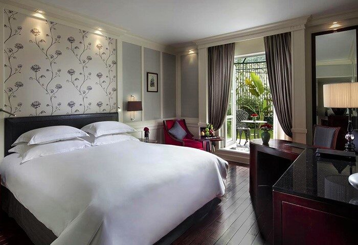 Sofitel Legend Metropole Hanoi Hotel room. Gay-friendly hotel with balcony, garden view. Luxury bedroom, king bed, desk. Hanoi travel.