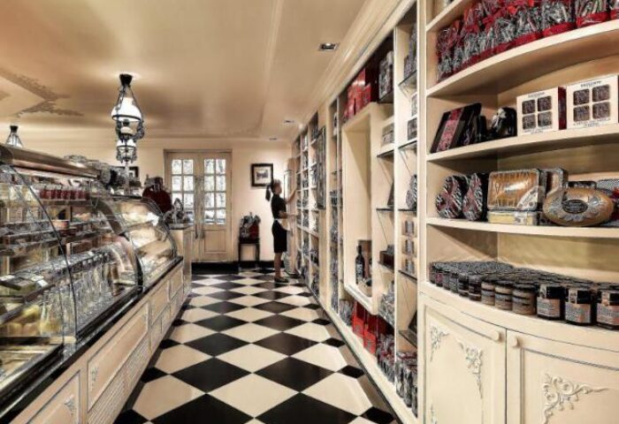 Sofitel Legend Metropole Hanoi Hotel's gay-friendly shop. Black & white tile floor, shelves stocked with treats, and a staff member.