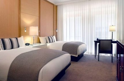 Sofitel Los Angeles at Beverly Hills Hotel: Gay-friendly hotel room with two beds, desk, chair, and striped pillows. Modern design.