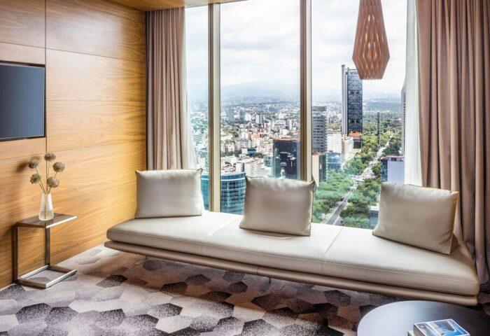 Sofitel Mexico City Reforma gay-friendly hotel room. Panoramic city view, modern design, couch, and stylish decor for gay travelers.