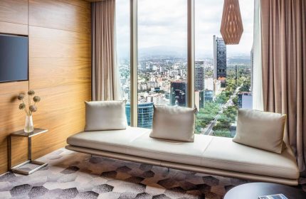 Sofitel Mexico City Reforma gay-friendly hotel room. Panoramic city view, modern design, couch, and stylish decor for gay travelers.